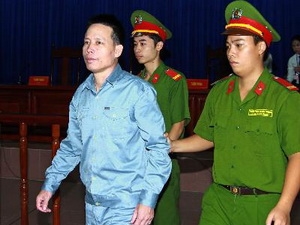 Cảnh sát dẫn giải bị cáo Đoàn Văn Vươn vào phòng xử án. Ảnh: Doãn Tấn - TTXVN