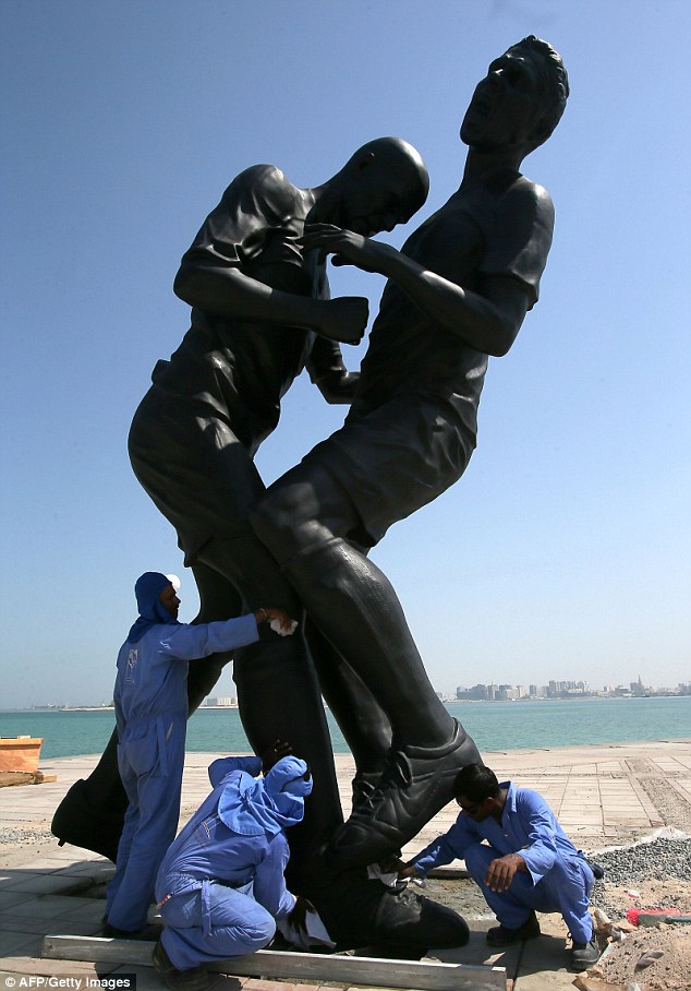  	Các công nhân đang lau chùi bức tượng