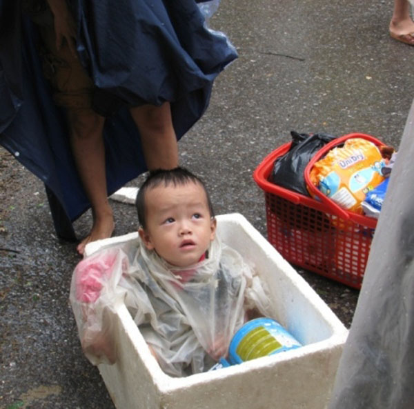 
	Cháu bé chạy lũ cùng hộp sữa.