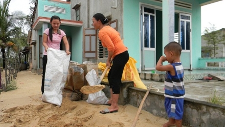 	Chị Trần Thị Thơ (41 tuổi ở khu dân cư Lộc Đông) nói: "Chồng đi làm biển ở đảo Phú Quốc (Kiên Giang) không về kịp, nên mấy mẹ con ở nhà phải xúc cát đổ vào bao tải kéo lên mái nhà chằng tôn. Từ nhỏ đến lớn dân ở đây chưa thấy cơn bão nào được dự báo là khủng khiếp như HaiYan. Phải nhanh	chằng chống nhà cửa trước khi được bộ đội đưa xe đến đón đi chiều nay”. Ảnh: Tiền phong