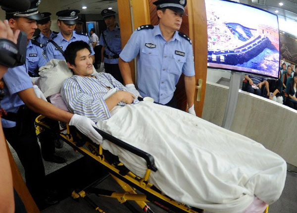  	Ji Zhongxing được cảnh sát đưa vào tòa trên giường bệnh, vẫn mặc bộ quần áo bệnh nhân. 
