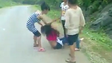 	Cô gái mặc áo màu đỏ bị đánh hội đồng (ảnh chụp từ clip)