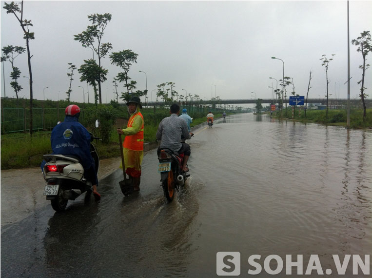 	Công nhân của công ty cổ phần quản lí đường bộ Hà Nội đã có mặt ở đây nhằm thông đường dẫn nước và hướng dẫn các phương tiện giao thông đi qua.