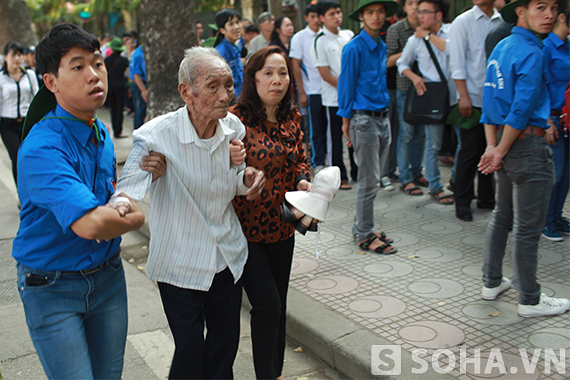 	Thanh niên tình nguyện giúp đỡ cụ ông di chuyển lên hàng trên để vào trước vì cụ đã tuổi cao sức yếu.