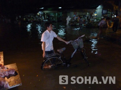 Một thanh niên lội bì bõm trong dòng nước triều.