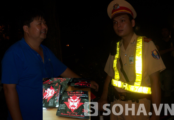 Trung tá Trần Anh Sơn(bên trái) cho biết đây là loại ma túy tổng hợp đóng gói kiểu lạ chưa từng gặp.