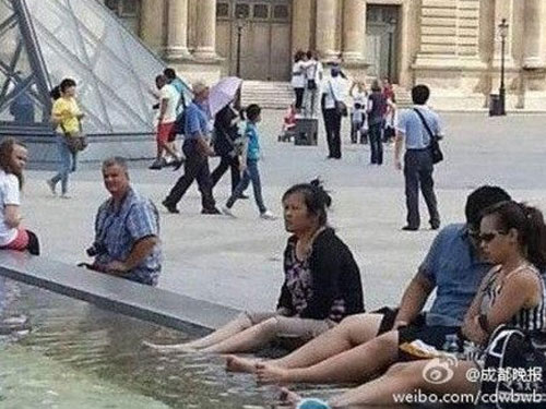 Một nhóm du khách Trung Quốc ngâm chân trong đài phun nước của bảo tàng Louvre (Pháp)