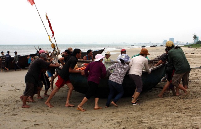 	Ngư dân thành phố Đà Nẵng chủ động giúp nhau kéo thuyền máy vào bờ để tránh trú bão số 10 tại bờ biển Thọ Quang. Ảnh: TTXVN