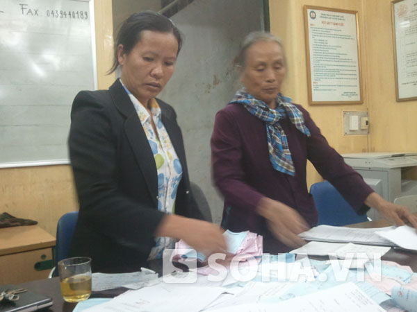 Chị Nguyễn Thị Mai cùng người chị dâu đang sắp xếp lại những giấy tờ liên quan đến việc gửi đơn kêu oan tới các cấp trong vòng 8 năm qua.