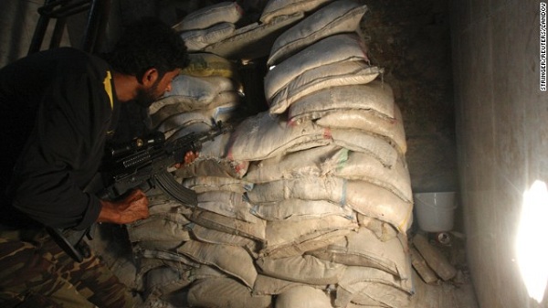 	Chiến binh lực lượng Syria tự do nấp sau những bao cát, sẵn sàng nổ súng.