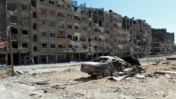 	Một chiếc ô tô đỗ trước cửa các tòa nhà ở Zamlka, ngoại ô Damacus bị bom phá hủy.