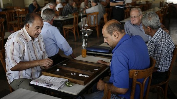 	Hai người đàn ông bình thản chơi cờ, hút thuốc trong một quán cafe tại Damacus hôm 25/8.
