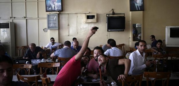 	Ba người đàn ông vui vẻ chụp ảnh tự sướng trong một quán cafe ở Damacus hôm 25/8.