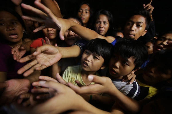 	Người dân vùng Las Pinas, phía nam thủ đô Manila, Philippines chen lấn nhau để nhận hàng cứu trợ sau bão.