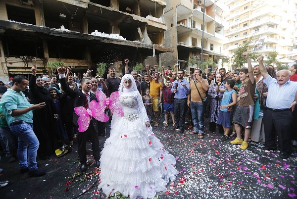 	Cô dâu và chú rể người Lebanon chụp ảnh cưới vào ngày 18/8 tại nơi vừa xảy ra một vụ nổ bom xe ở Beirut khiến ít nhất 27 người thiệt mạng.