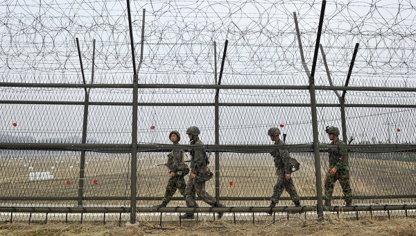 	Các binh sĩ Triều Tiên tuần tra dọc hàng rào dây thép gai phân chia biên giới Hàn - Triều.