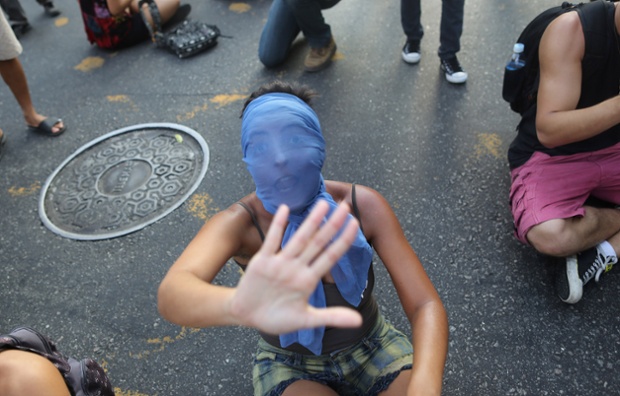 Một cô gái đeo mặt nạ la hét trong khi tham gia cuộc biểu tình phản đối tăng giá vé xe bus ở Rio de Janeiro, Brazil.