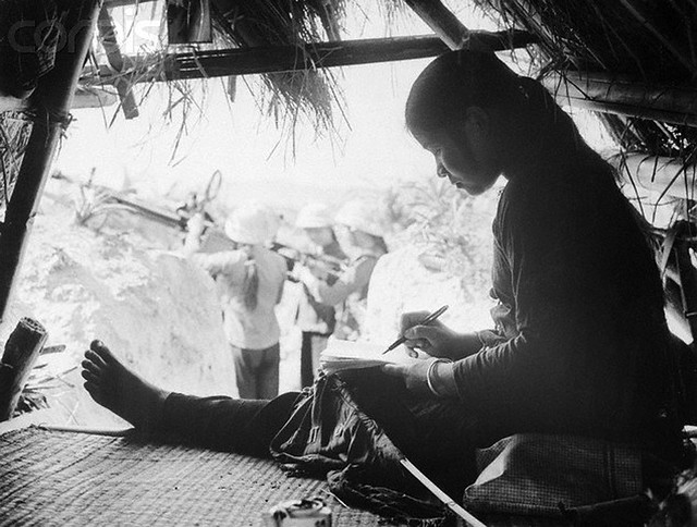 13 Feb 1968, North Vietnam --- A young North Vietnamese girl takes some time to write a letter home during a break in fighting somewhere in North Vietnam. --- Image by © Bettmann/CORBIS