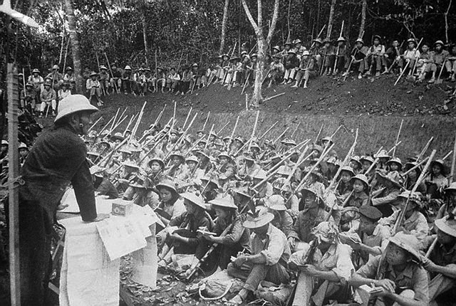 November 22, 1967, Near Hanoi, North Vietnam --- Outdoor Class. Near Hanoi, North Vietman: Some with riflres, but most with just sticks at their sides, students of the College of Transportation hold outdoor class after their school in Hanoi was evacuated recently. ca. November 22, 1967. --- Image by © Bettmann/CORBIS