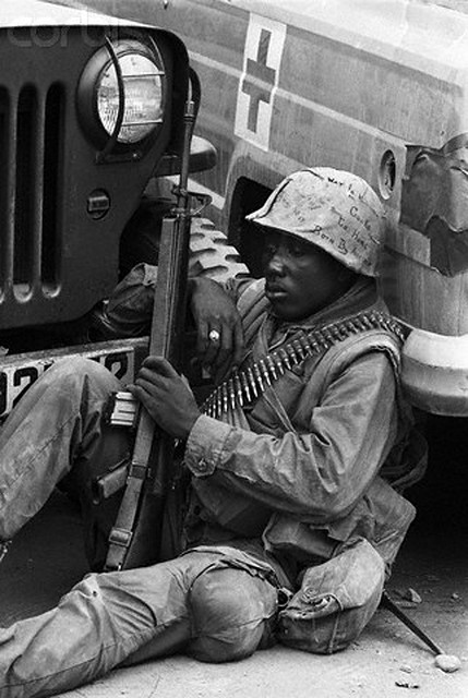 09 Feb 1968, Hue, South Vietnam --- HUE, SOUTH VIETNAM-2/9/68-: With ammunition slung over his shoulder and a rifle in his hand, this American GI has a quiet moment for thought during a pause in the fighting at Hue. A week after the first enemy assault in this area, allied forces were making slow progress in clearing Hue of Viet Cong and North Vietnamese troops. --- Image by © Bettmann/CORBIS