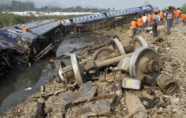 Nhân viên cứu hộ và người dân đứng cạnh một đoàn tàu khách trật đường ray ở bang Assam, Ấn Độ.