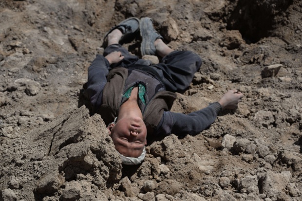 Cậu bé mồ côi mất gia đình trong thảm họa lở đất, đau buồn nằm trên đất ở Badakhshan, miền bắc Afghanistan.