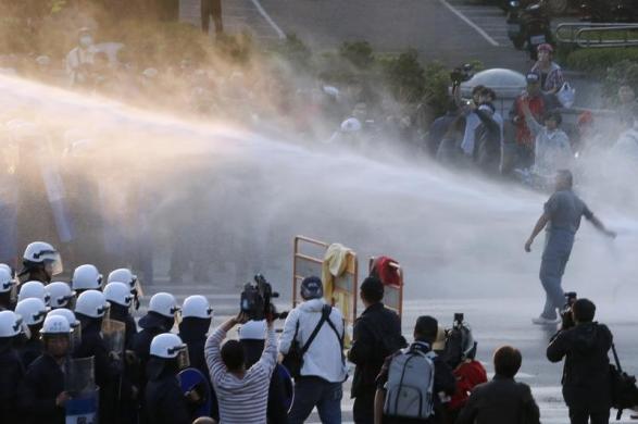 Cảnh sát sử dụng vòi rồng phun nước giải tán người biểu tình phản đối hiệp định thương mại Đài Loan – Trung Quốc ở bên ngoài tòa nhà chính phủ ở Đài Bắc.