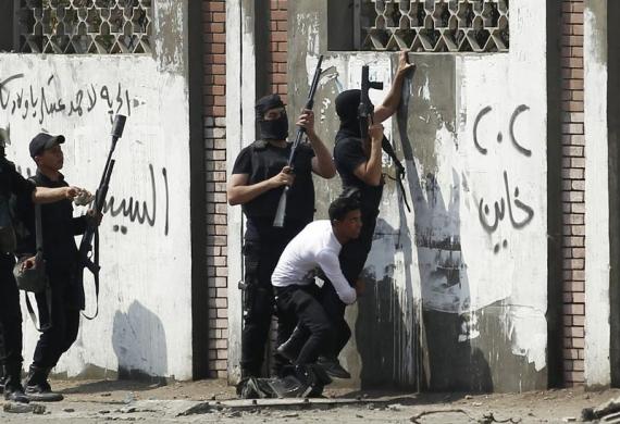 Cảnh sát chống bạo động nhấc đồng đội để bắn đạn hơi cay trong cuộc đụng độ trước đại học Al-Azhar ở Cairo, Ai Cập.