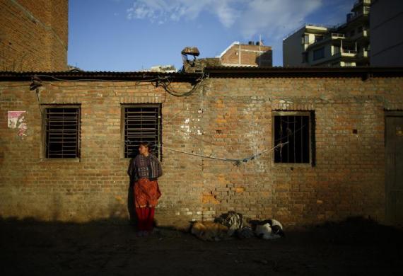 Một phụ nữ đứng bên ngoài lò mổ dọc đường phố ở Kathmandu, Nepal.