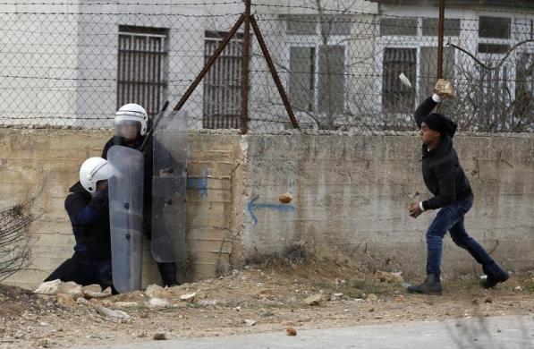 Một thanh niên Palestine ném đá vào cảnh sát Israel bên ngoài trại tị nạn Jalazoun, Bờ Tây.