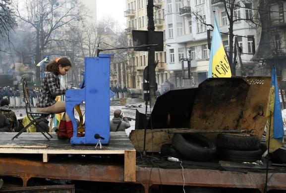 Một nghệ sĩ chơi đàn piano ngay trên hàng rào do người biểu tình chống chính phủ dựng ở Kiev, Ukraine.