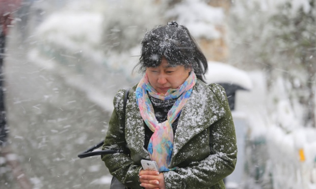 Một phụ nữ đi dưới mưa tuyết ở Urumqi, Trung Quốc.