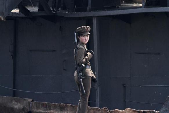 Một nữ binh sĩ Triều Tiên đứng bảo vệ dọc bờ sông Yalu gần thị trấn Sinuiju, đối diện với thành phố Đan Đông, Trung Quốc.