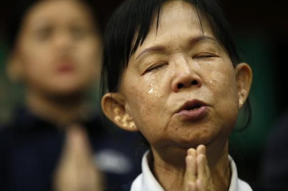 Một người tình nguyện giúp đỡ thân nhân của hành khách trên chuyến bay MH370 khóc khi cầu nguyện cho các hành khách tại khách sạn Lido ở Bắc Kinh, Trung Quốc.
