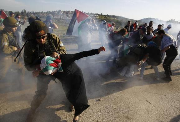 Binh sĩ Israel bắt giữ một phụ nữ Palestine trong một cuộc biểu tình yêu cầu mở cửa khẩu biên giới tại khu vực Ramallah, Bờ Tây.