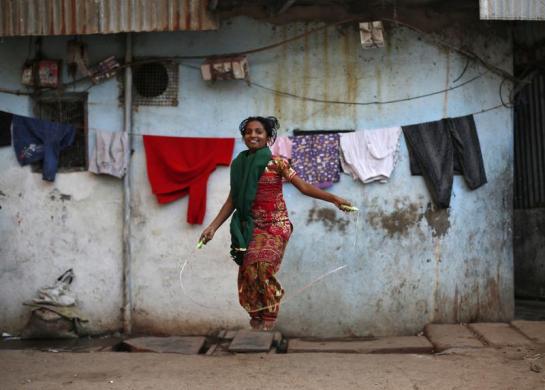 Một thiếu nữ nhảy dây ngoài nhà tại khu ổ chuột Dharavi ở Mumbai, Ấn Độ.