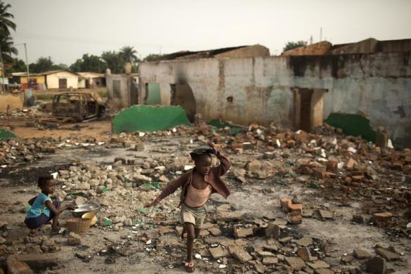 Một bé gái chạy qua đống đổ nát của những ngôi nhà bị phá bỏ Miskine, thủ đô Bangui, Trung Phi.