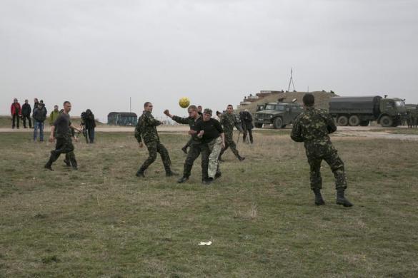 Các binh sĩ Ukraine chơi bóng đá cạnh các phương tiện quân sự Nga tại sân bay Belbek ở Crimea.