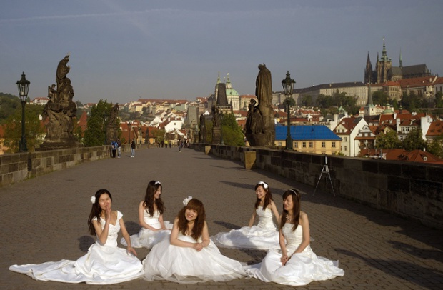 Các cô dâu chờ được chụp ảnh trên cầu Charles ở Prague, CH Czech.