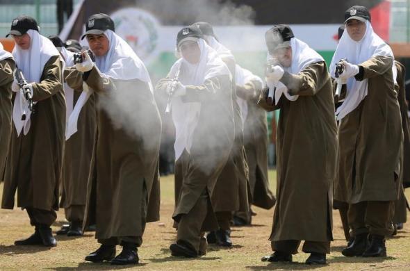 Các nữ thành viên của lực lượng an ninh Palestine trung thành với nhóm Hamas, trình diễn kỹ năng bắn súng trong lễ tốt nghiệp quân sự ở thành phố Gaza.