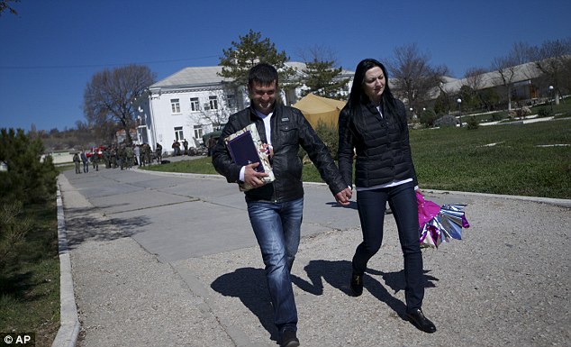 Lieutenants Galina Volosyanchik, right, and Ivan Benera, left, walk away from the base after their union