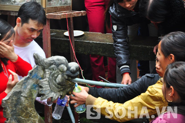 Sau khi làm lễ, người dân mang chai, lọ ra sát vách đá hứng nước tạo nên cảnh chen lấn xô đẩy, hỗn loạn.