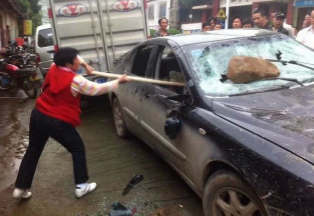 Revenge: One angry villager attacks the two thieves car in Sanjiang Village, Guangxi