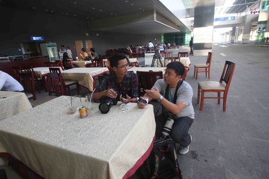 Phóng viên nước ngoài và phóng viên VN cùng trao đổi thông tin ở ngoài sảnh sân bay