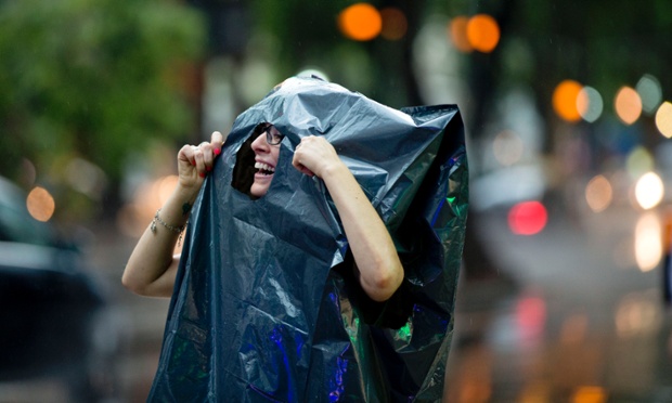 Một phụ nữ dùng túi đựng rác để che mưa ở Buenos Aires, Argentina.