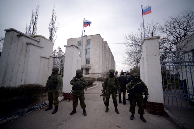 Các binh sĩ Nga đứng trước cổng sau khi chiếm quyền kiểm soát căn cứ hải quân ở Novoozerne, Tây Crimea.