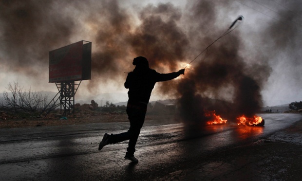 Một người biểu tình người Palestine sử dụng súng cao su để bắn đá về phía quân đội Israel trong cuộc đụng độ ở Silwad, Bờ Tây.