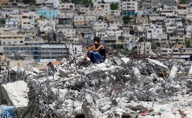 Một người Palestine ngồi trên đống đổ nát của một ngôi nhà bị máy ủi của Israel phá hủy tại trại tị nạn Al-Aroub, gần Hebron.