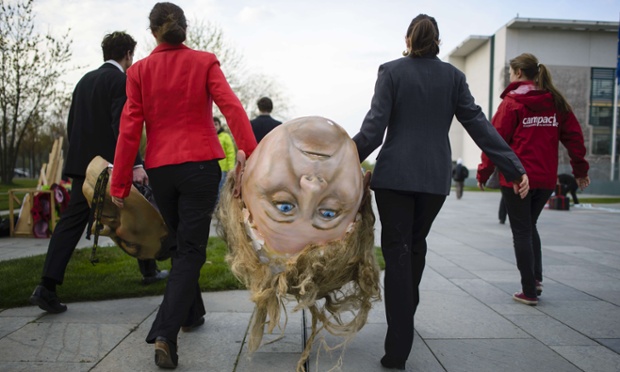 Các nhà hoạt động môi trường mang một chiếc mặt nạ khổng lồ mô phỏng Thủ tướng Đức Angela Merkel trước cuộc biểu tình trước tòa nhà chính phủ ở Berlin.