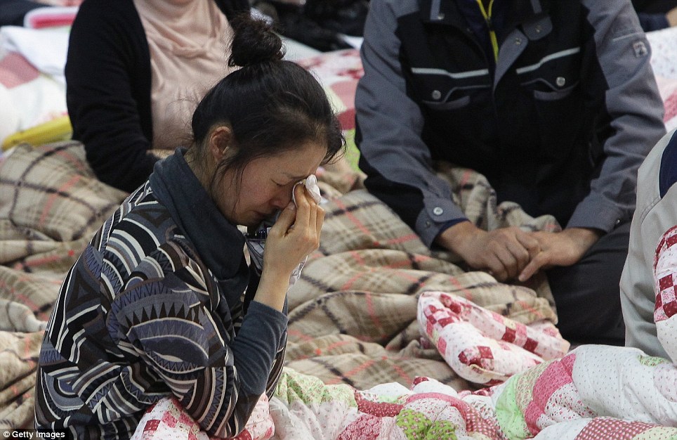 Nước mắt: Một người phụ nữ khóc khi cô ngồi giữa các thân nhân khác của hành khách mất tích